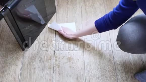 白色女性手巾用纸巾把水洒在地板上日光瓷砖用仿木家庭主妇打扫房子视频的预览图