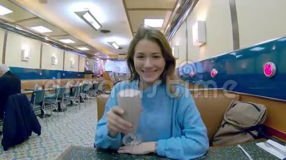 快乐的女人在典型的美国餐馆喝奶昔视频的预览图