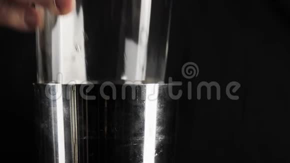 经典玛格丽塔鸡尾酒酒保拿着一个玻璃杯放在一个黑色背景的波士顿摇床上视频的预览图