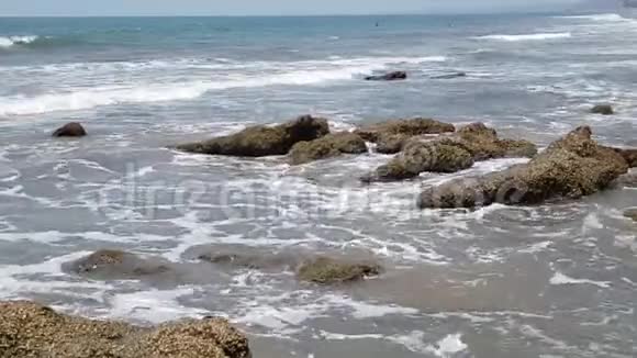 波浪在岸边与岩石碰撞水溅了夏日的黑暗视频的预览图