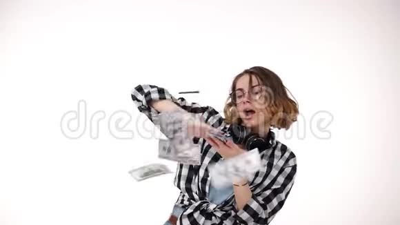 一个漂亮的卷曲短发女孩的缓慢动作赢得了很多钱并把美元的钞票从空中扔出去视频的预览图