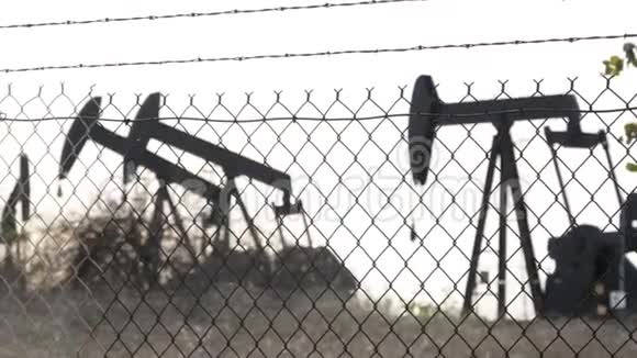 工业城市景观洛杉矶的拉布雷亚英格尔伍德井泵千斤顶在栅栏后面工作钻机视频的预览图