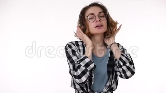 漂亮的少女穿着格子衬衫带着大耳机音乐跳舞唱歌感觉很好的概念视频的预览图