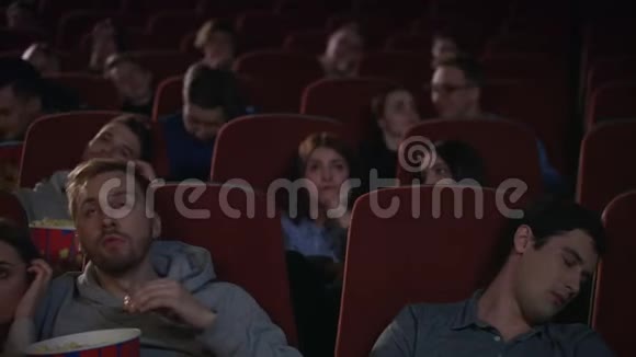 无聊的观众离开电影院而会议在慢动作不感兴趣的电影视频的预览图