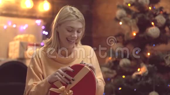 微笑的年轻女子在家里打开圣诞礼物感恩节和圣诞节新年礼物圣诞快乐视频的预览图