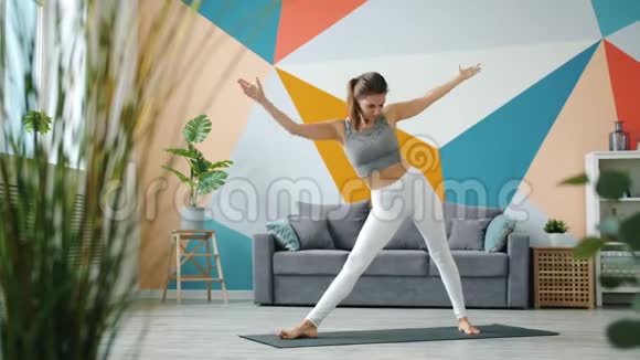 穿着紧身裤和在家做瑜伽的可爱女士画像视频的预览图