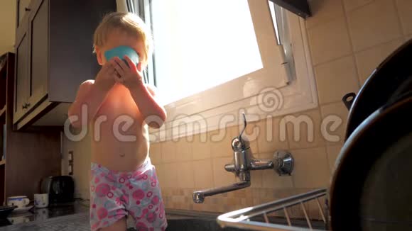 喘息呛人的概念儿科背景幼儿一边喝水一边站在厨房的水槽里宝贝女儿视频的预览图