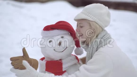 冬天快乐的女人在下雪的冬天散步时堆雪人主题圣诞假期冬新年冬天快乐视频的预览图