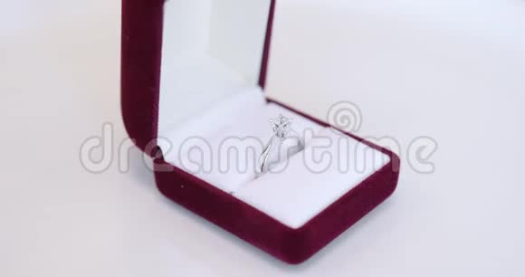 旋转新的白金白金婚礼新娘戒指在精致的现代红色盒子白色背景特写视频的预览图