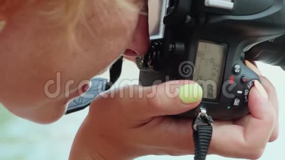 特写女摄影师用专业相机拍照拍摄摄影时看镜头的女人视频的预览图