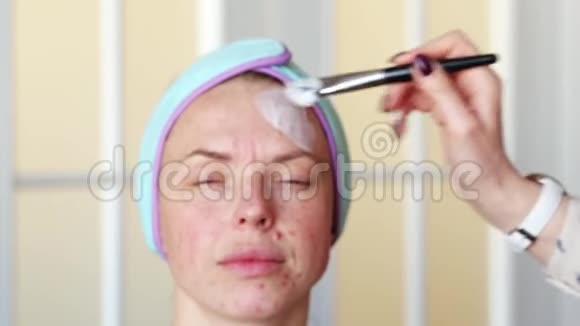 化妆师在化妆前女孩的脸涂上保湿面膜手术在家里进行视频的预览图