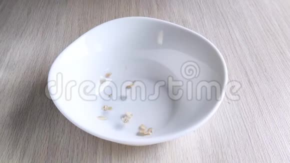干燕麦片倒入空白碗中烹饪健康营养早餐特写镜头白天视频的预览图