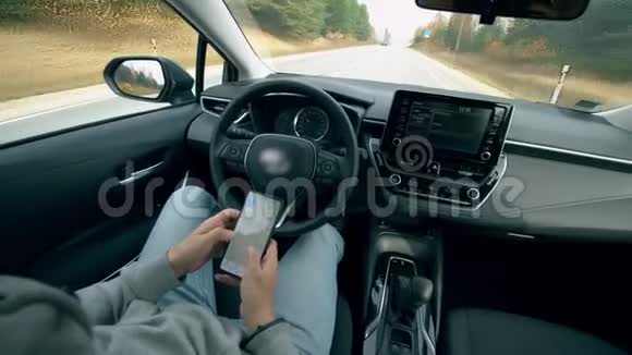 一个人用手机工作而一辆汽车在自动驾驶视频的预览图