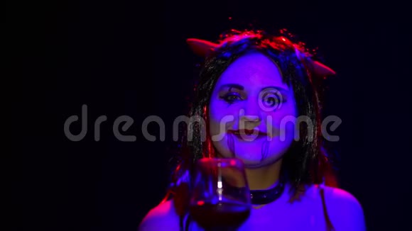 带着不祥笑容的女人魔鬼手里拿着杯子喝血视频的预览图