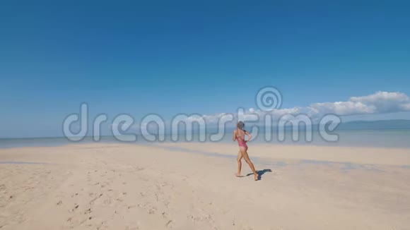 在热带岛屿的晴天亚洲女孩正在海边的沙滩上奔跑视频的预览图