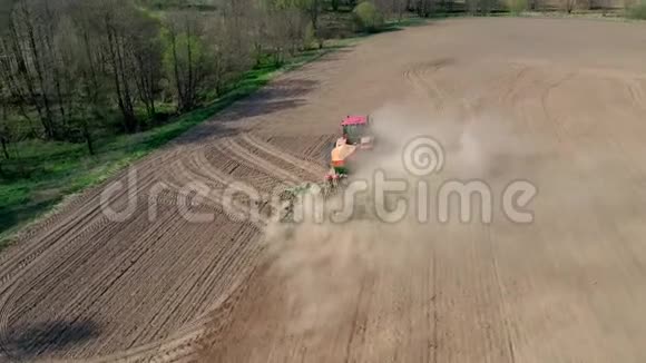有机质粒种子的拖拉机在粉尘农业田间空中作业视频的预览图