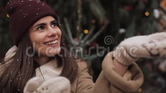 站在外面微笑着在圣诞节接过雪花的冬装少女的特写镜头视频的预览图