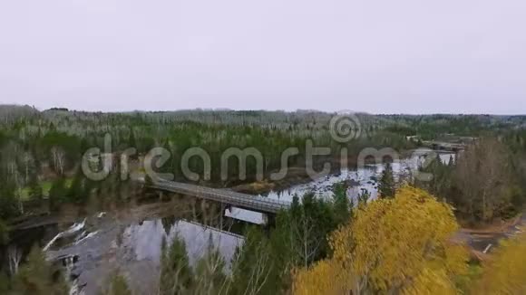 无人机摄像机走近一座桥桥上有一条路和一片秋林加拿大安大略省卡米尼斯蒂基亚河视频的预览图
