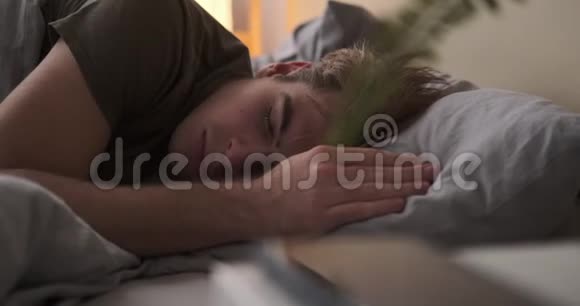 男人醒来在床上检查他的手机视频的预览图