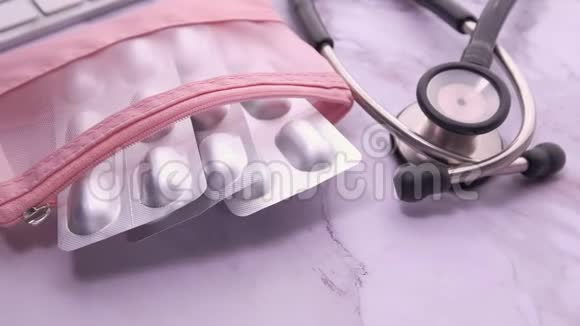 粉红色背景下的水泡包听诊器和药丸盒的俯视图视频的预览图