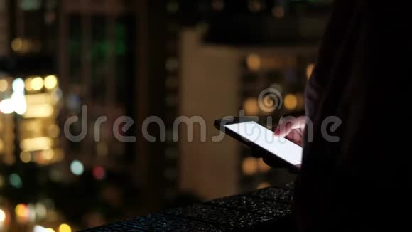 接近的女性晚上使用智能手机视频的预览图