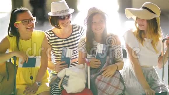 四位身穿夏季服装的不伦不类正坐在机场的候车室里面有护照和车票视频的预览图