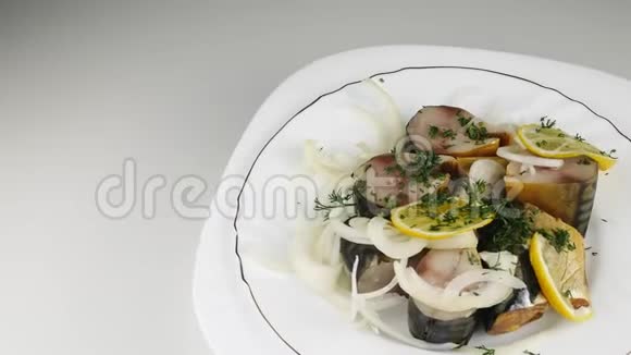 白色盘子里有洋葱的咸鱼鲭鱼碎片旋转成一个圆圈视频的预览图