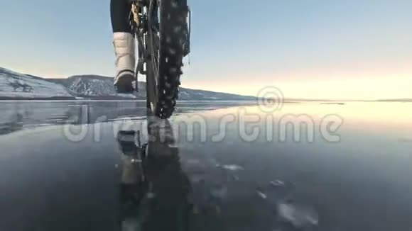 轮胎的视图拍摄60fps动作凸轮女人在冰上骑自行车冰的贝加尔湖轮胎视频的预览图