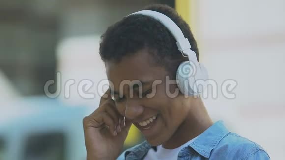 非洲裔美国男青少年戴着耳机在音乐节奏情绪中移动视频的预览图