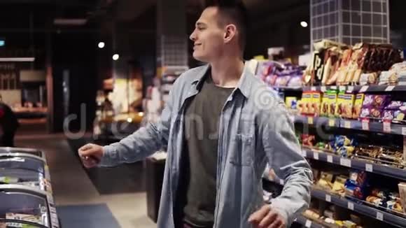 在超市快乐时尚的男人与自由跳舞在大购物中心前面的货架与商品积极正面视频的预览图