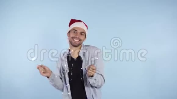 新年快乐年轻的白种人穿着休闲装戴着圣诞帽手里拿着两个星星挥舞着他们视频的预览图