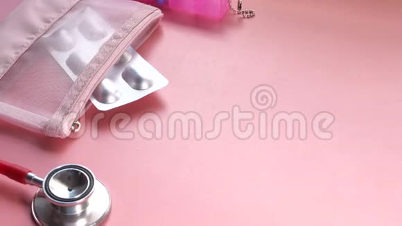 粉红色背景下的水泡包听诊器和药丸盒的俯视图视频的预览图