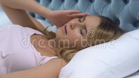 女人感到恶心躺在床上揉太阳穴发烧感染病毒视频的预览图