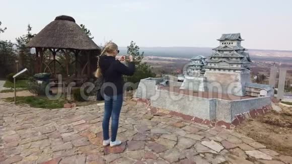 女人在一座中国日本小塔附近拍照迷你公园视频的预览图