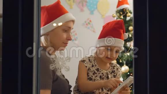 圣诞前夜坐在窗边的母女俩读了这本书视频的预览图