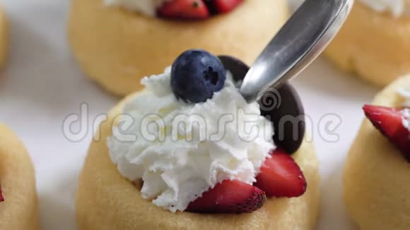 迷你饼干杯与新鲜浆果和鲜奶油接近白色背景视频的预览图
