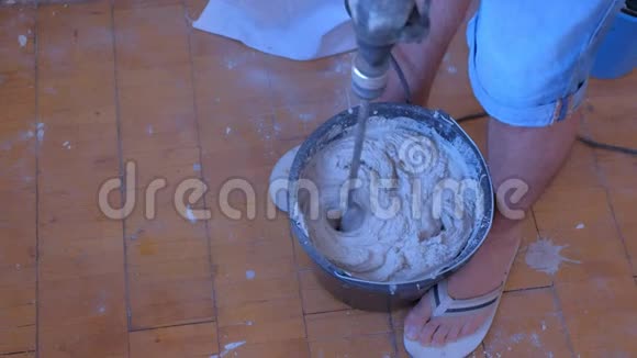 搅拌机搅拌水泥灰泥在桶内使用电动搅拌机特写视图视频的预览图