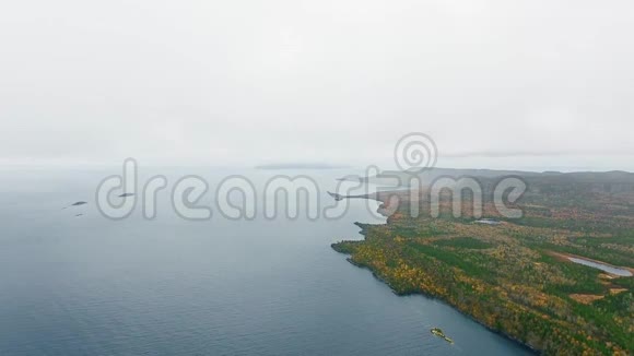 空中相机拍摄地平线以上的湖泊与茂密的森林加拿大安大略省大湖区苏必利尔湖视频的预览图