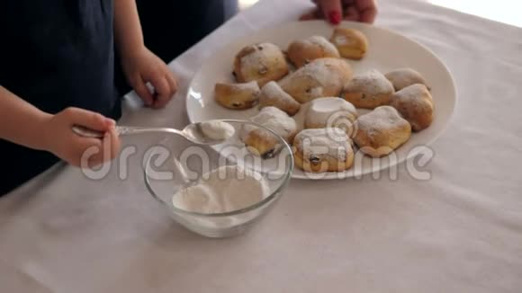 一位母亲和一个小女儿的特写镜头在饼干上撒上糖粉视频的预览图