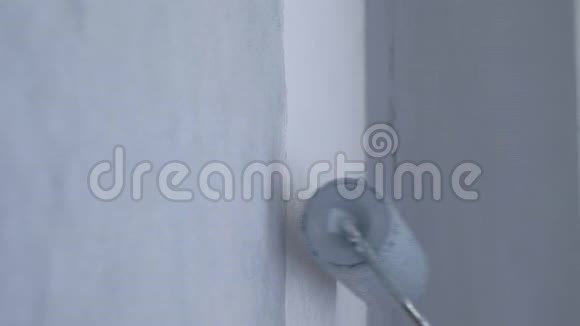 粉刷白色墙面在灰色采用油漆滚筒特写侧视视频的预览图