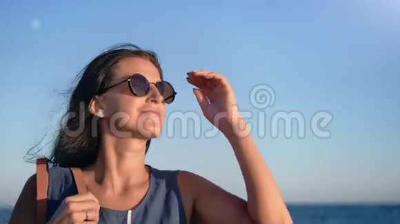 日落时分在沙滩上散步的一位年轻快乐的女士头发是深色的视频的预览图