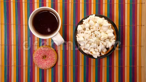 把爆米花放在碗里桌上放茶和甜甜圈视频的预览图