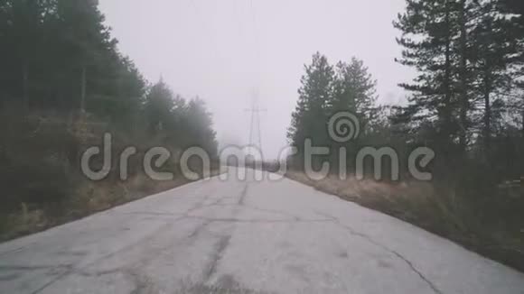 在城市道路上的沥青上飞行照相机在山雾雾雾雾雾雾雾森林多云冷冬天电影院视频的预览图