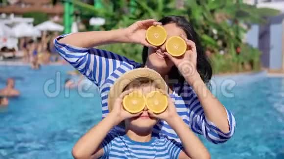 快乐的旅行家庭摆着半只橙色的眼睛在游泳池度假胜地玩视频的预览图