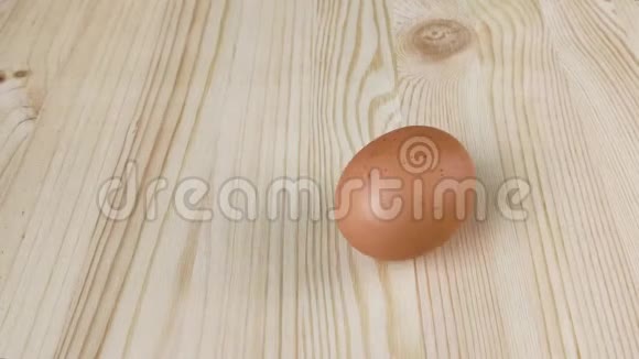 棕色的鸡蛋在木桌上旋转检查煮熟的鸡蛋的准备情况特写视频的预览图