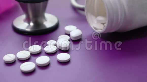 紫色背景的容器听诊器和药盒视频的预览图