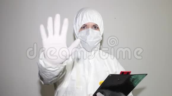 带着覆盖物和防护面罩来对抗冠状病毒的卫生工作者举起她的手作为停止的标志视频的预览图