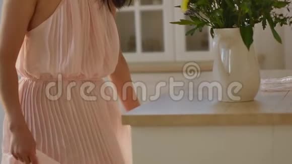 一位美丽的亚洲年轻女子的肖像她穿着一件精致的粉红色连衣裙手里拿着春天的花一个女人视频的预览图
