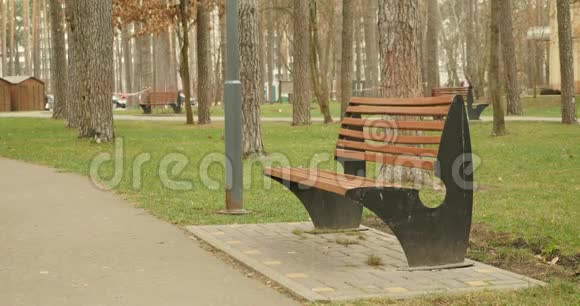 年轻的女孩走向长凳拿着书坐着开始读一本脱黑帽子的书在公园的概念阅读视频的预览图