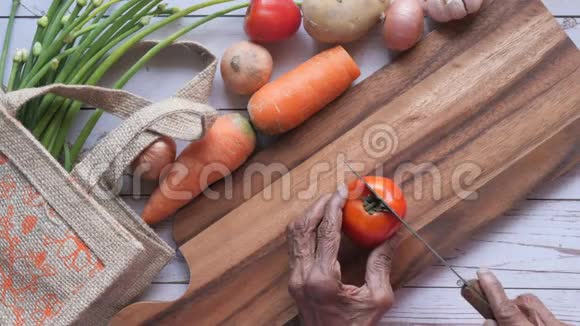 老妇人在家做饭厨房切番茄视频的预览图